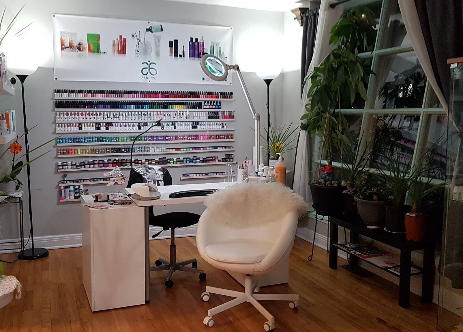Stylish nail care station at T.C. Spa, Ottawa, Ontario, CA with lush plants and colorful nail polish display.
