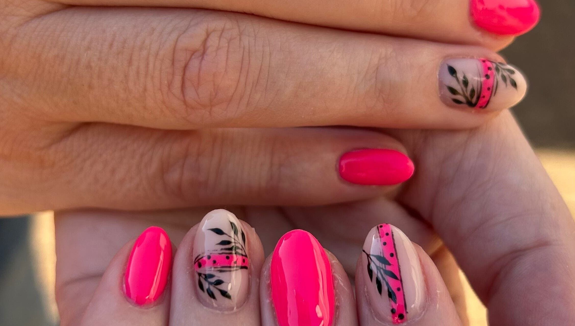 Blooming Nails in Tzaneen, Limpopo, ZA showcases vibrant floral nail art in stunning pink and black designs.