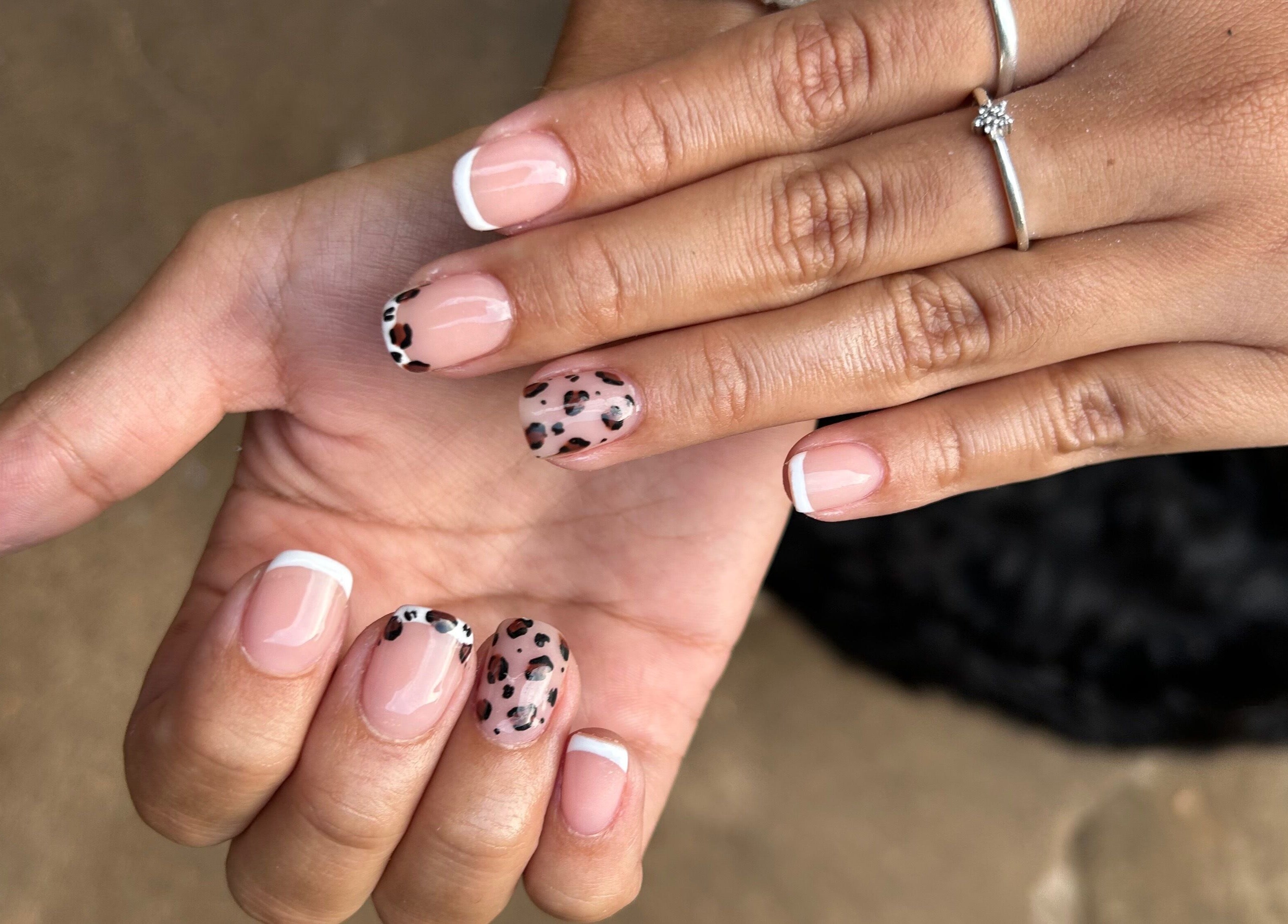 Elegant nail art with French tips and leopard design at Blooming Nails, Tzaneen, Limpopo, ZA.
