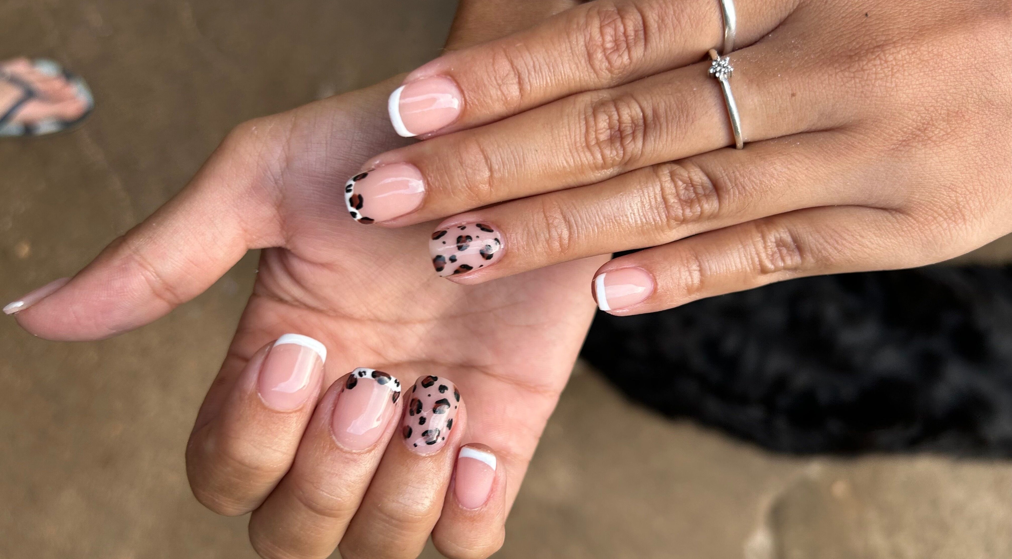 Elegant nail art with French tips and leopard design at Blooming Nails, Tzaneen, Limpopo, ZA.