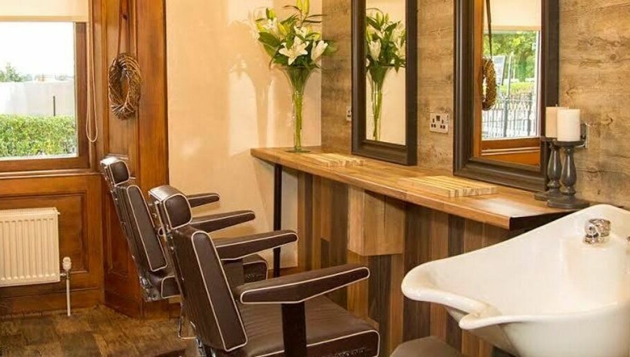Elegant salon interior at Park West Spa, Hamilton, Scotland, GB featuring brown chairs and wooden decor.