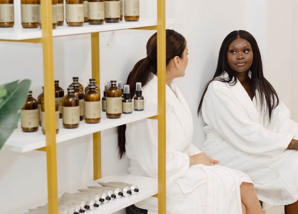 Guests relax in robes at Dilaani Medical Aesthetics & Head Spa, Ottawa, Ontario, CA with products on shelves.