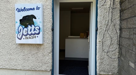 Entrance to Jetts Wash in Glasgow, Scotland, GB with welcoming sign on exterior wall.
