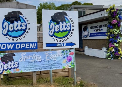 Jetts Wash venue signage in Glasgow, Scotland, GB, featuring colorful flowers and grand opening banners.