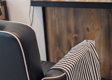 Modern barber chair with striped cape at BSharp Barbershop, Melbourne, Victoria, AU.