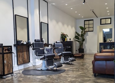 Elegant interior of BSharp Barbershop in Melbourne, Victoria, AU featuring modern chairs and rustic decor.