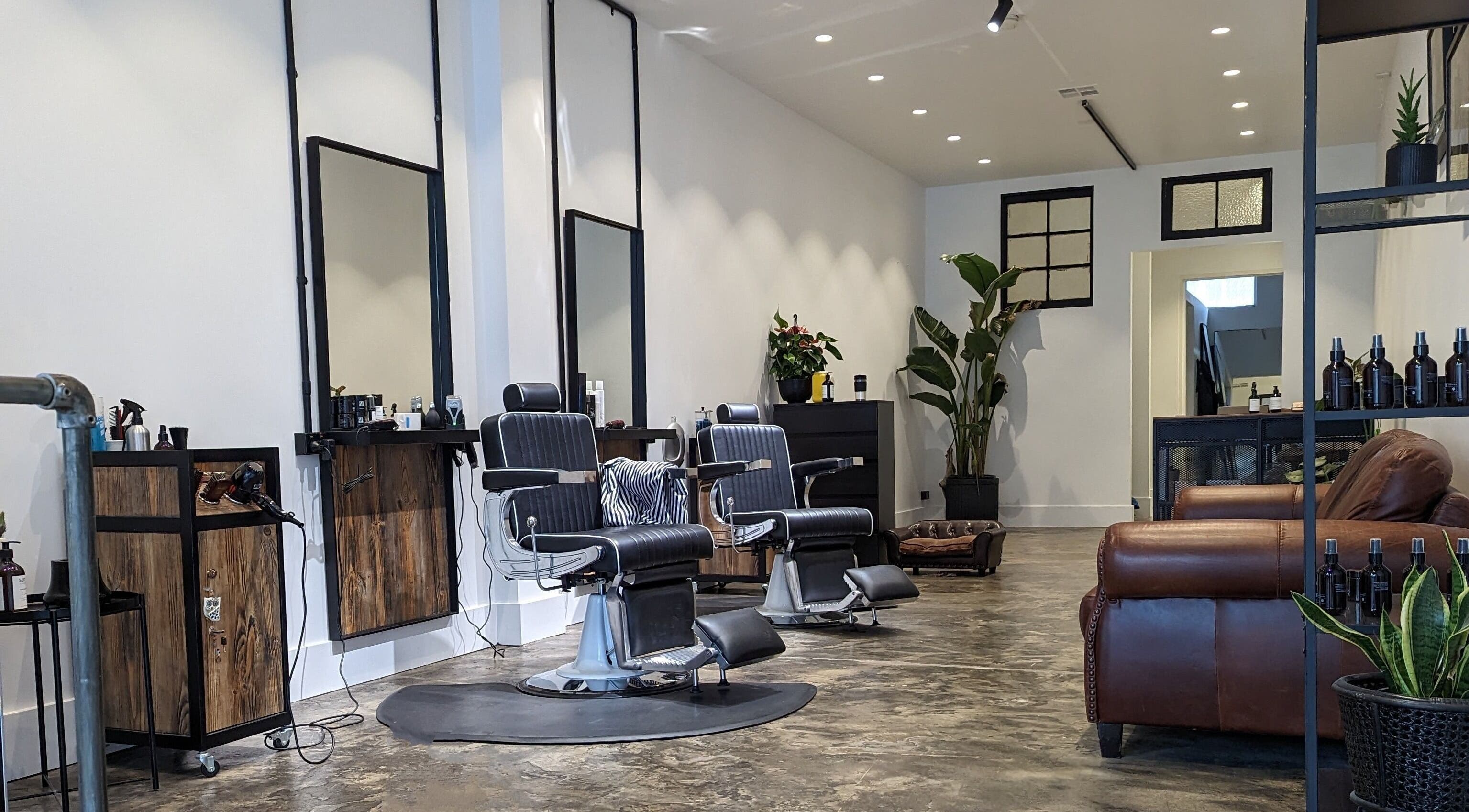 Elegant interior of BSharp Barbershop in Melbourne, Victoria, AU featuring modern chairs and rustic decor.