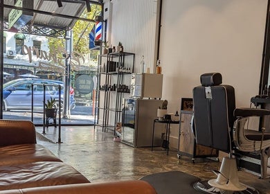 BSharp Barbershop in Melbourne, Victoria, AU featuring a luxurious leather sofa and chic styling chair.