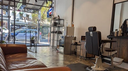 BSharp Barbershop in Melbourne, Victoria, AU featuring a luxurious leather sofa and chic styling chair.