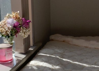 Warm sunlight on cozy bed with flowers at Dolled Up By Lily, Kelmscott, Western Australia, AU.