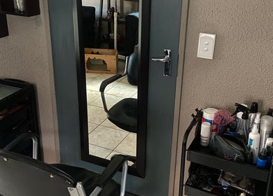 Salon chair and mirror at Cutz Hair Crew, Randburg, Gauteng, ZA with styling tools on shelves.
