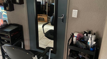 Salon chair and mirror at Cutz Hair Crew, Randburg, Gauteng, ZA with styling tools on shelves.