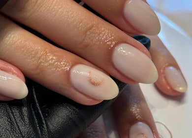 Manicured nails with subtle gold detail at The Secret Beauty Bar LDN, London, England, GB.