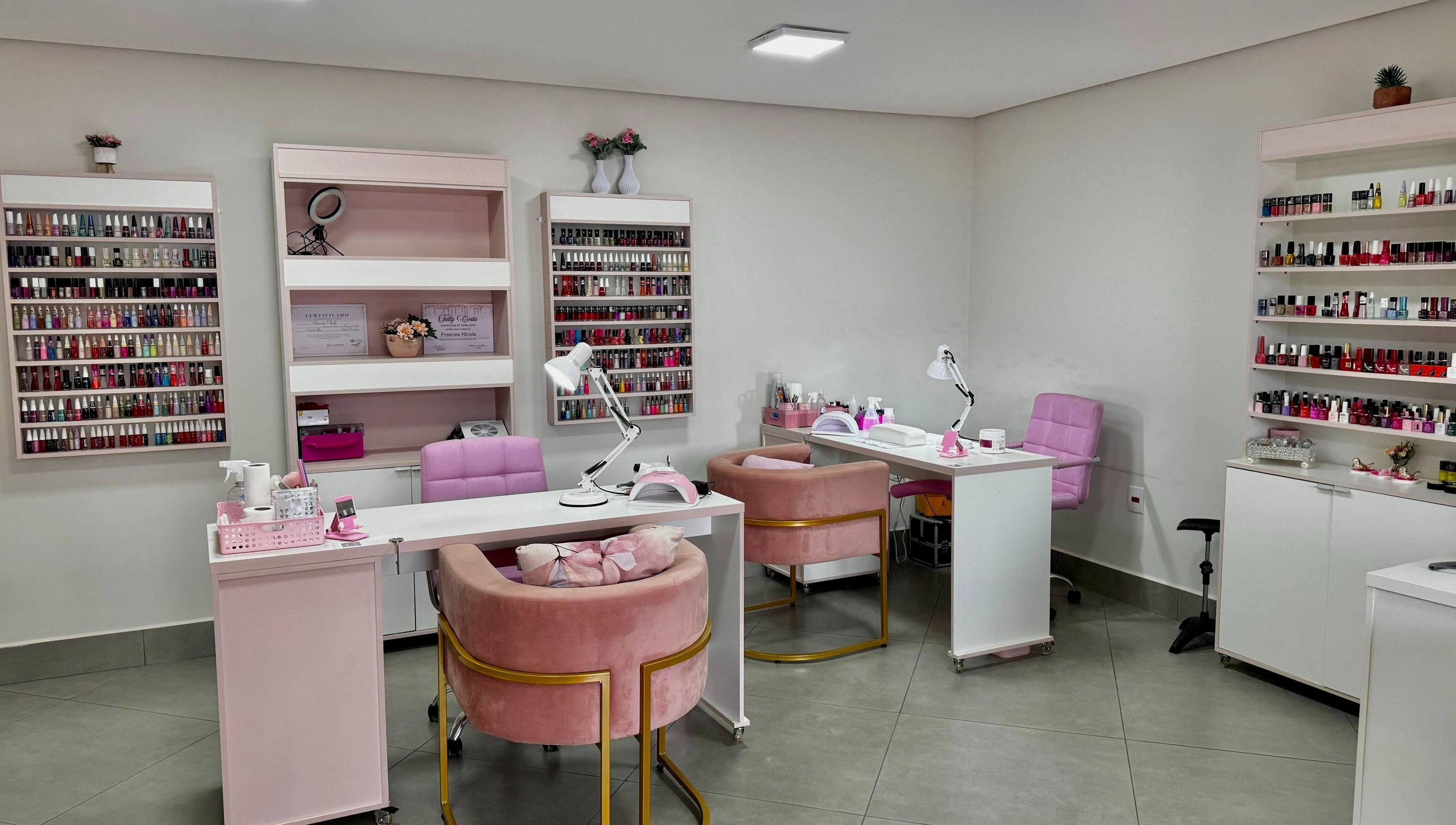 Interior elegante do Loucas Por Esmaltes Bauru, com poltronas rosa e esmaltes em Bauru, São Paulo, BR.