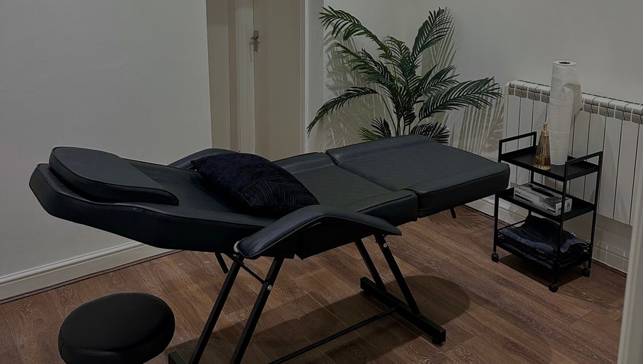 A serene massage room with a black massage table at Renū (Liverpool), Liverpool, England, GB.