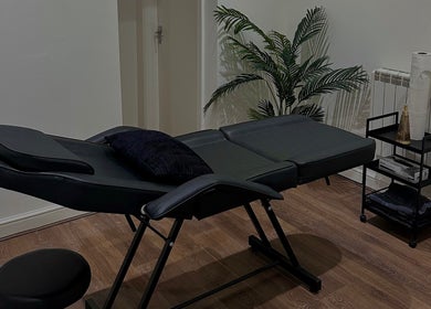 A serene massage room with a black massage table at Renū (Liverpool), Liverpool, England, GB.