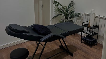 A serene massage room with a black massage table at Renū (Liverpool), Liverpool, England, GB.