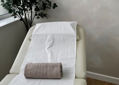 Relaxing massage table setup at Renū, West Kirby, England, GB, with a plant for a calming ambiance.