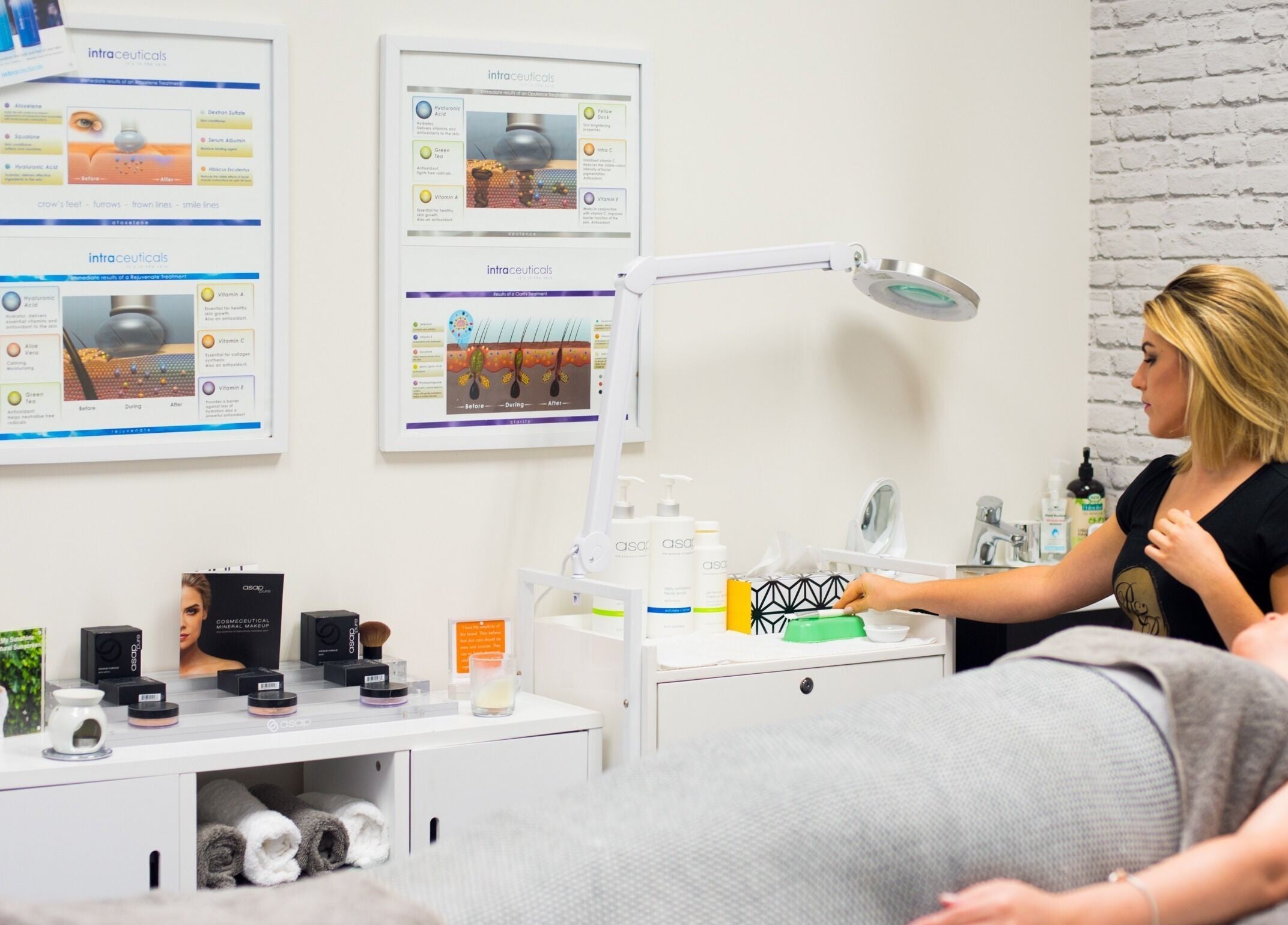Therapist at R&R Skin Care Clinic in Auckland, NZ, preparing for a facial treatment in a serene setting.