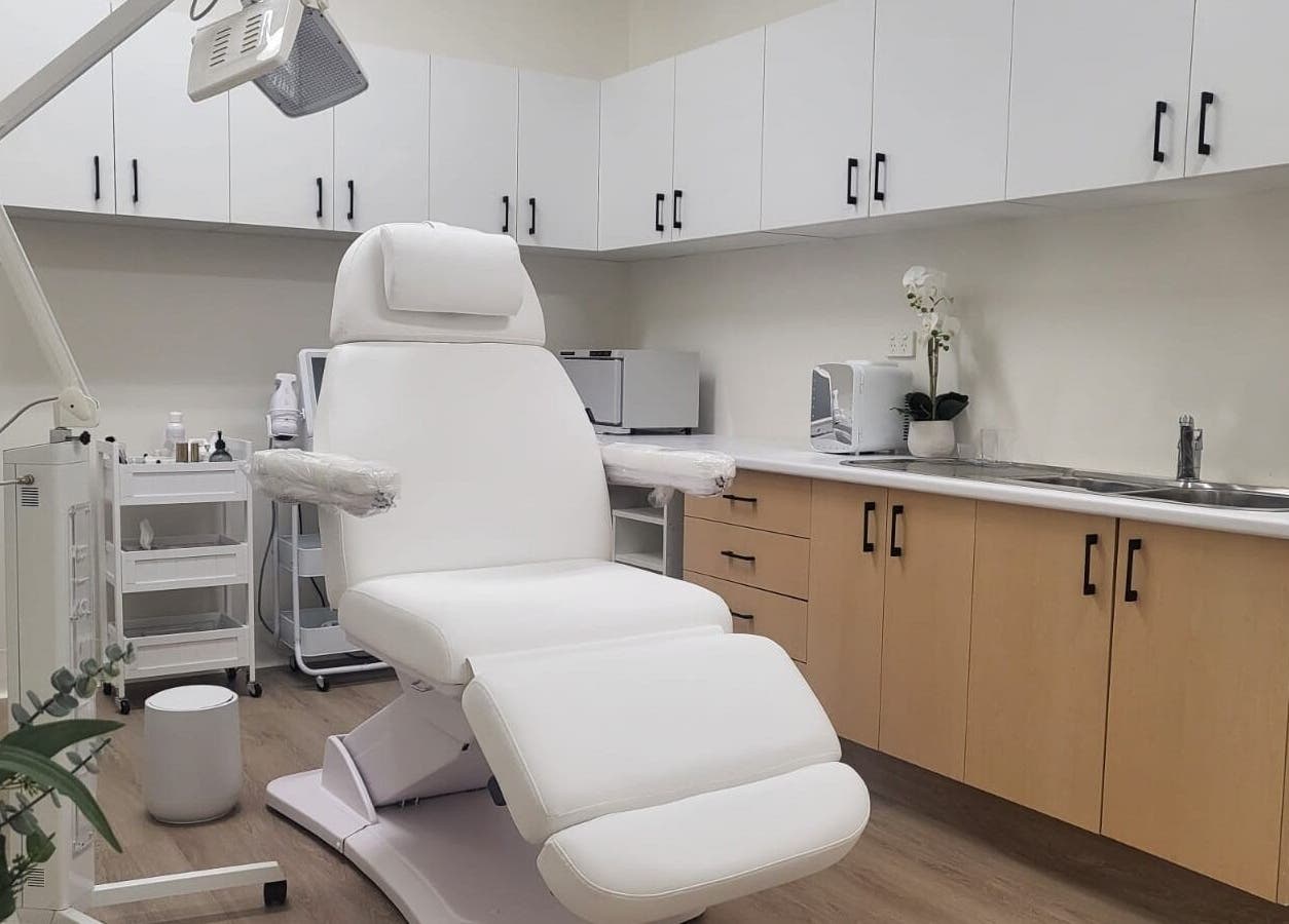 Modern treatment room at Lumina Skincare Clinic, Gold Coast, Queensland, AU with white chair and cabinets.