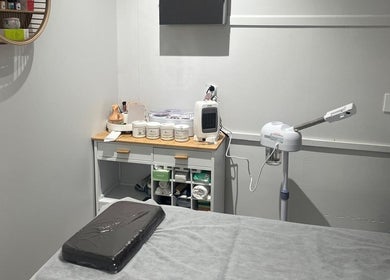 Relaxing spa room at Reshu’s Beauty & Nails NEW LYNN, Auckland, NZ with treatment table and skincare products.
