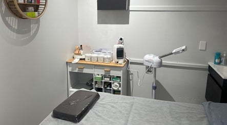 Relaxing spa room at Reshu’s Beauty & Nails NEW LYNN, Auckland, NZ with treatment table and skincare products.