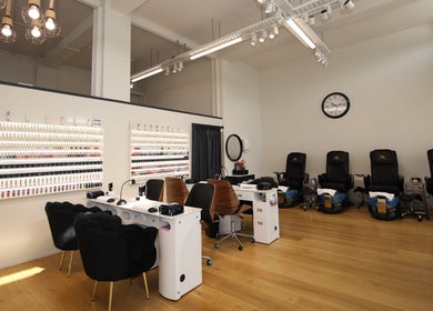 Stylish interior of Reshu's Beauty & Nails PONSONBY in Auckland, NZ showcasing multiple nail stations and chairs.