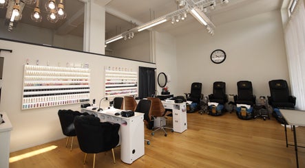 Stylish interior of Reshu's Beauty & Nails PONSONBY in Auckland, NZ showcasing multiple nail stations and chairs.