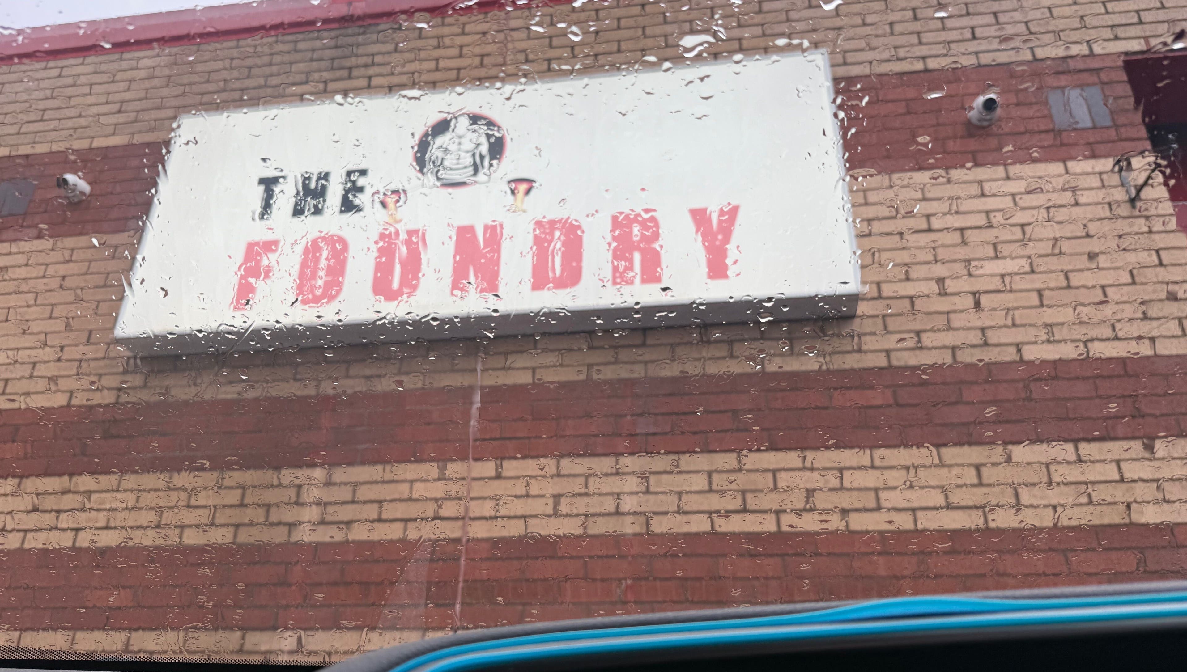 Sign for 'The Foundry' at chubby_charles_services, Paisley, Scotland, GB on a rainy day.