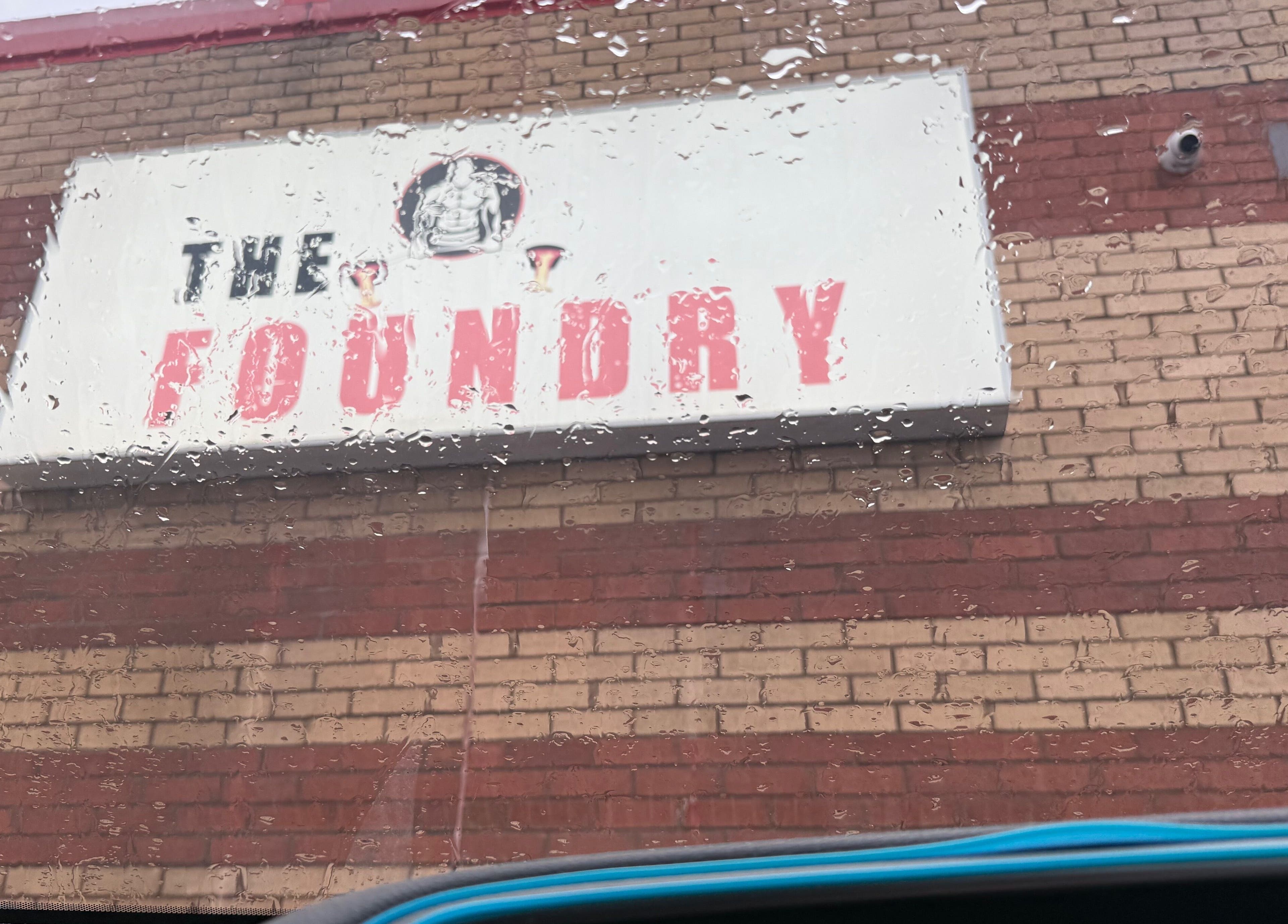 Sign for 'The Foundry' at chubby_charles_services, Paisley, Scotland, GB on a rainy day.