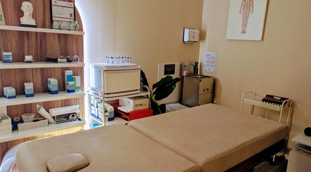 Therapy room at Holistic Therapies by Camille, Cardiff, Wales, GB, featuring treatment bed and shelves.