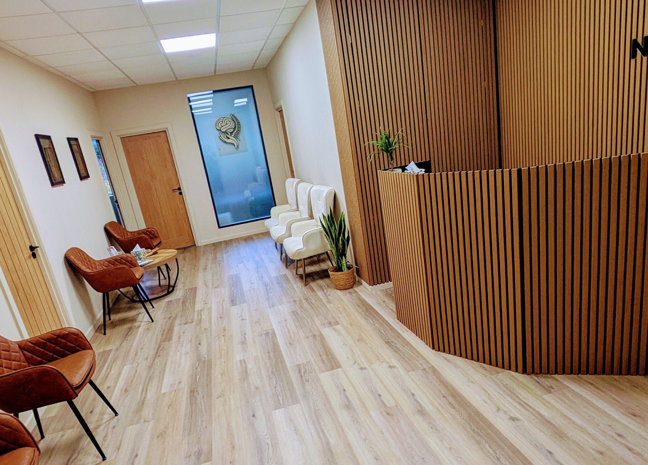 Elegant reception area at Holistic Therapies by Camille, Cardiff, Wales, GB, with modern seating and wooden decor.