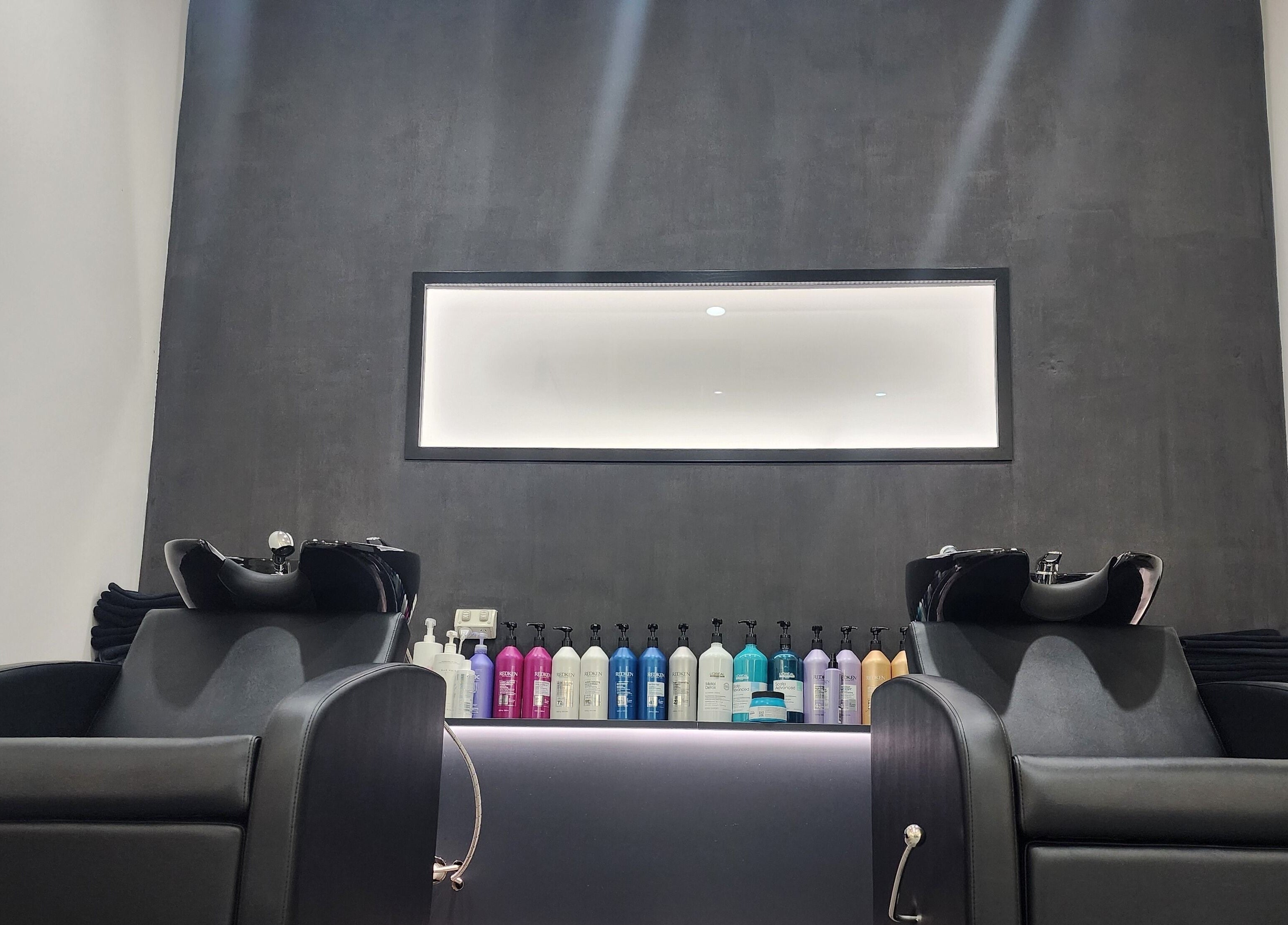 Modern wash stations at Clipz Hair Design, Morningside, QLD, AU featuring sleek chairs and hair products.