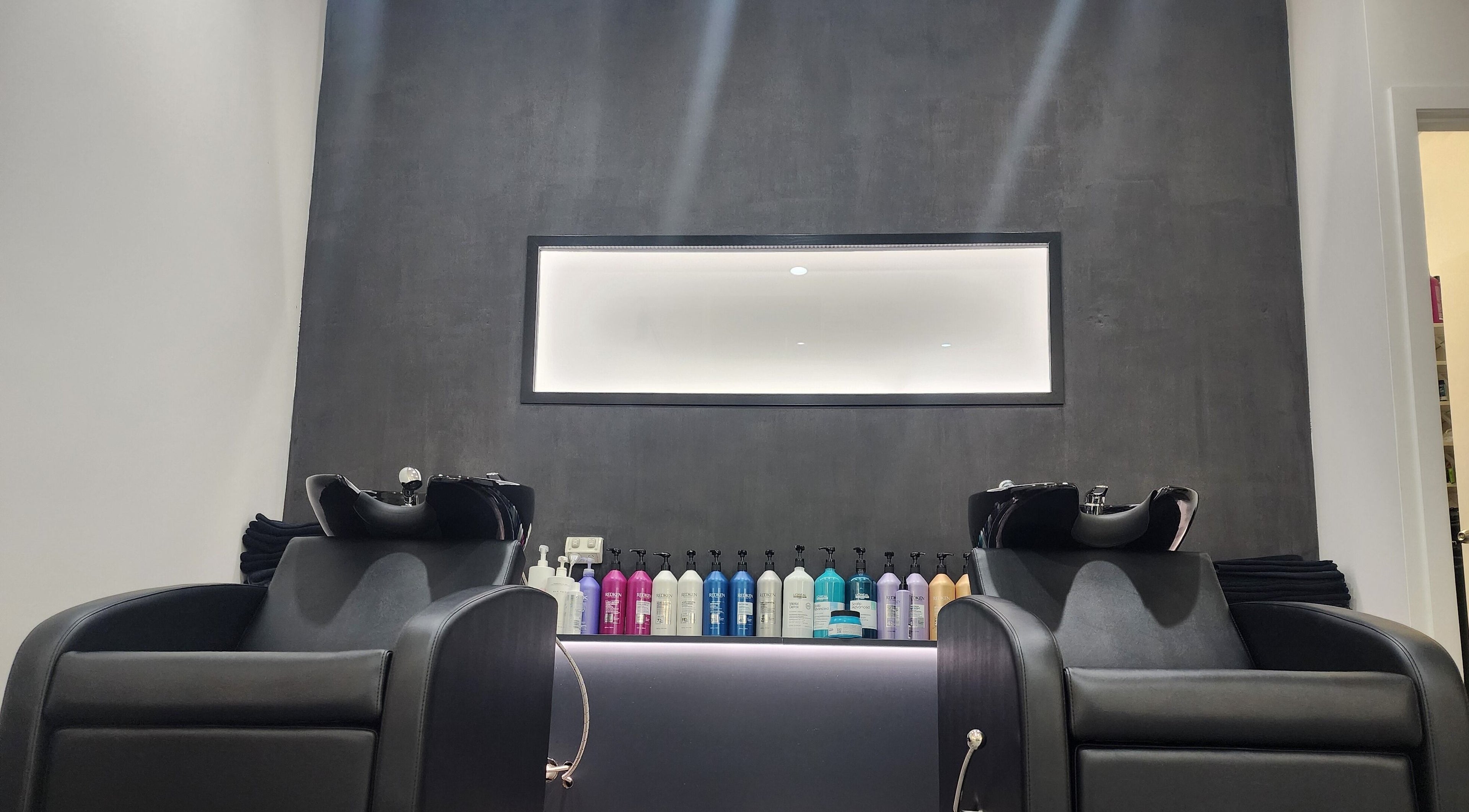 Modern wash stations at Clipz Hair Design, Morningside, QLD, AU featuring sleek chairs and hair products.