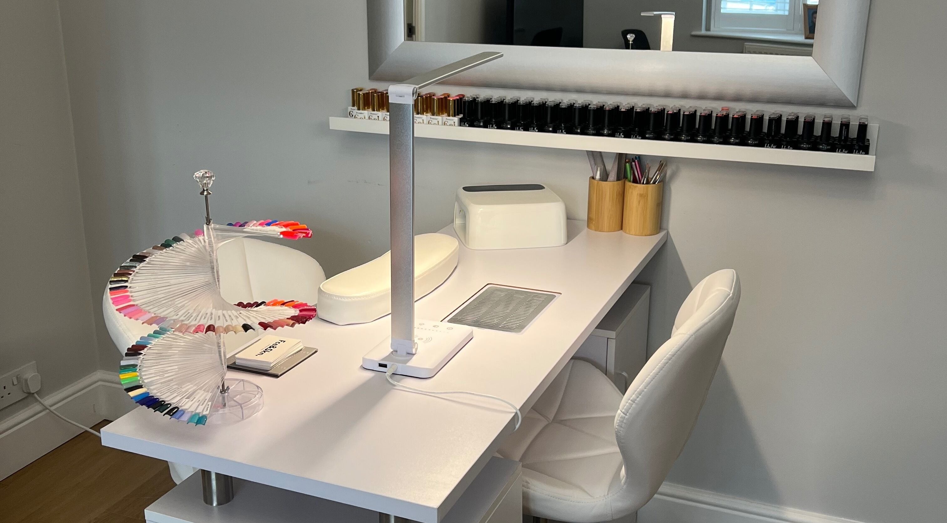 Modern nail station at House Of Beauty, Hornchurch, England, GB, featuring a sleek workspace and vibrant nail colors.