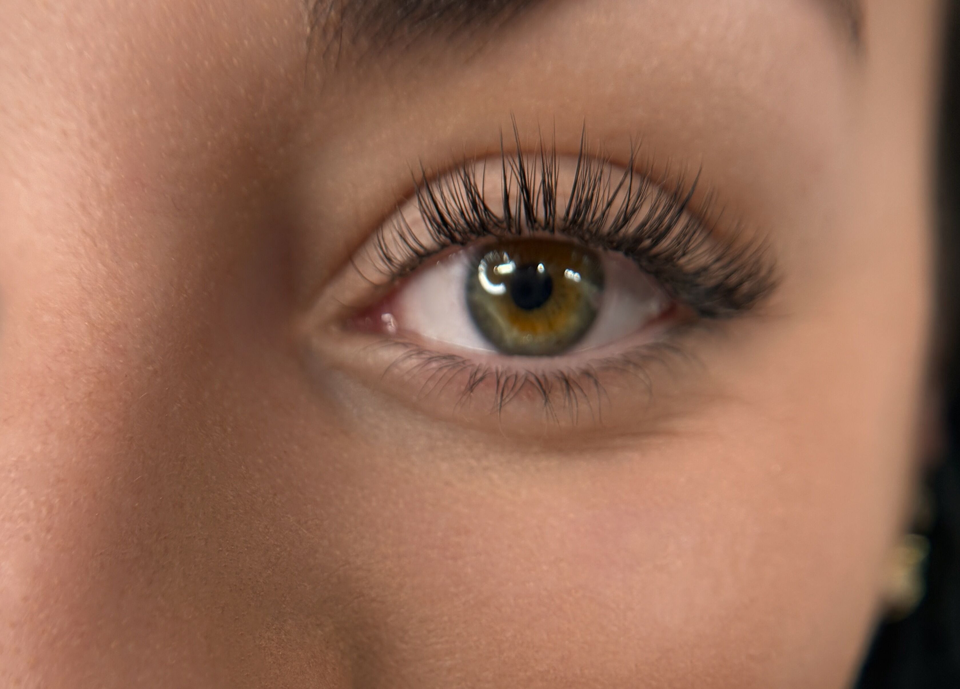 Close-up of an eye with long lashes, showcasing Suburban Glow's services in Wilmslow, England, GB.