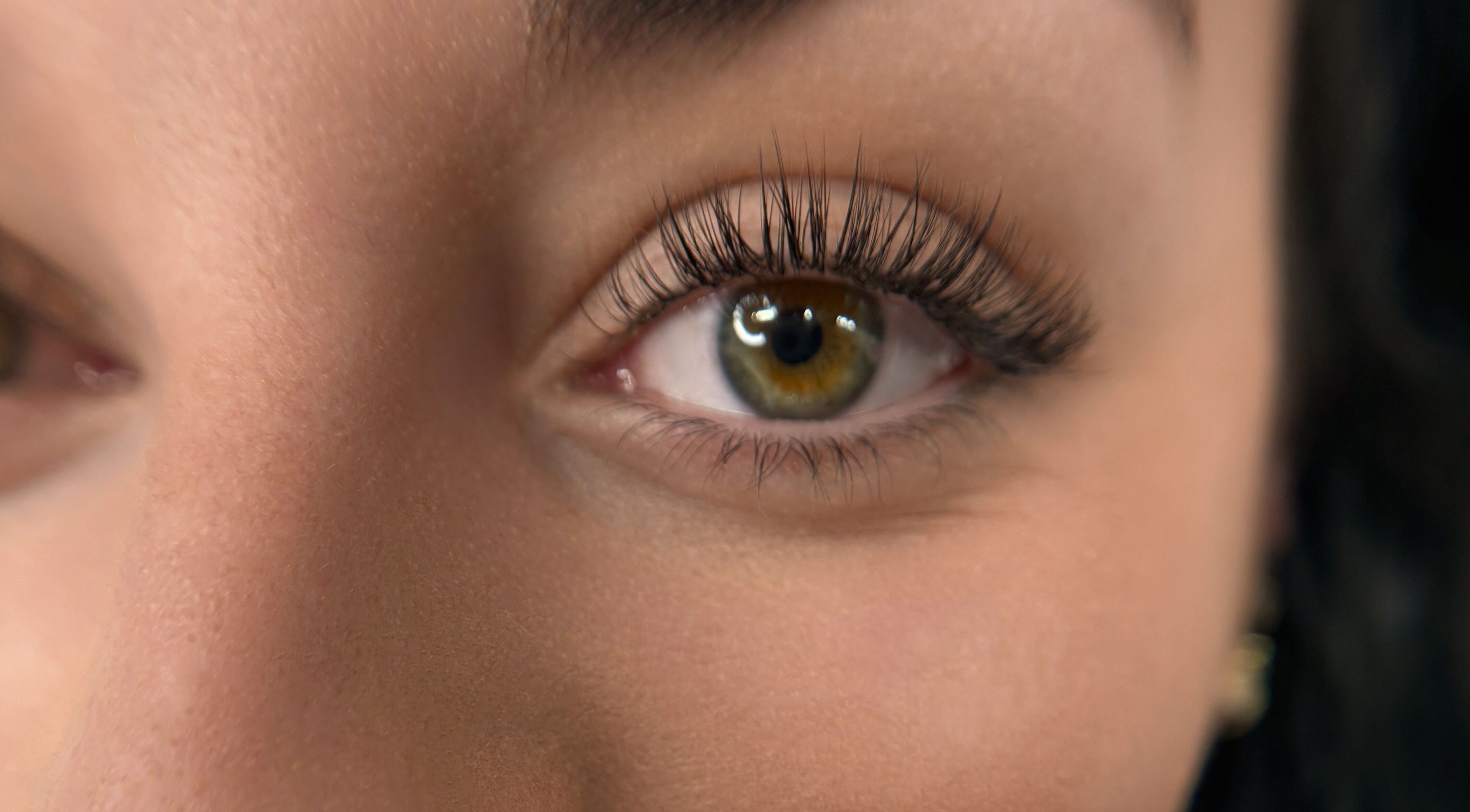 Close-up of an eye with long lashes, showcasing Suburban Glow's services in Wilmslow, England, GB.