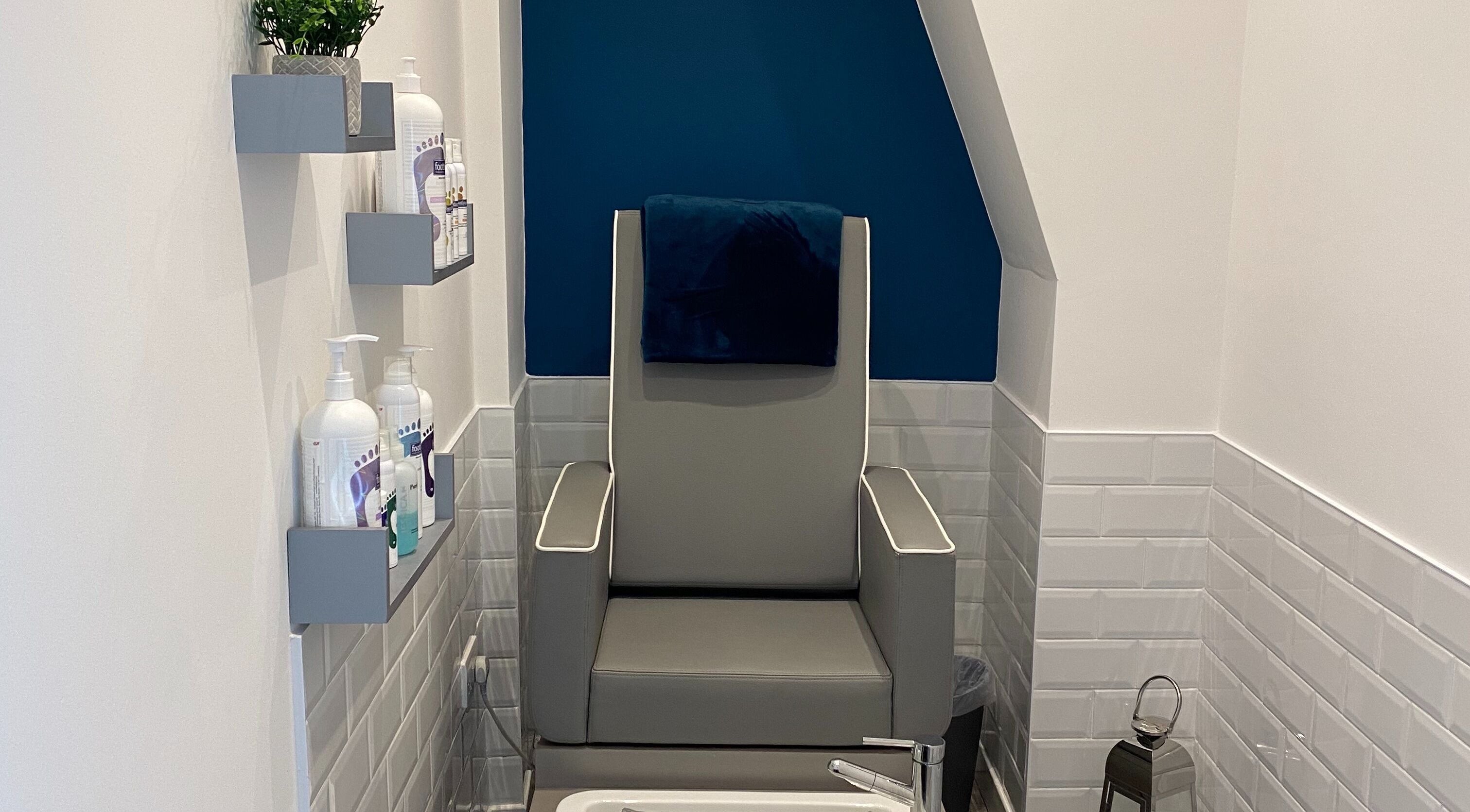 Pedicure chair in Polished House Of Beauty, Bury, England, GB, surrounded by sleek shelves and modern decor.