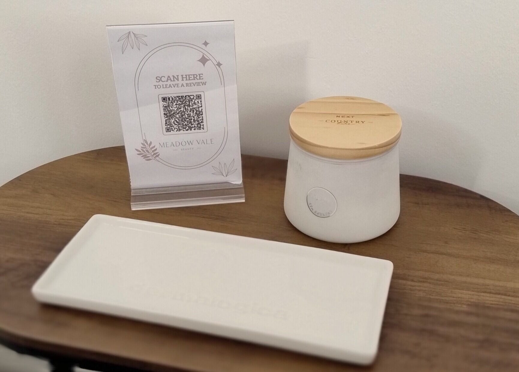 A cozy corner at Meadow Vale Beauty, Cottingham, England with a scented candle and review QR code.