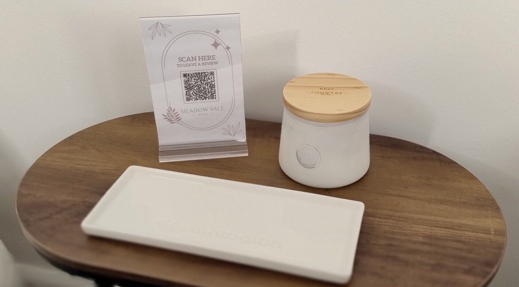 A cozy corner at Meadow Vale Beauty, Cottingham, England with a scented candle and review QR code.