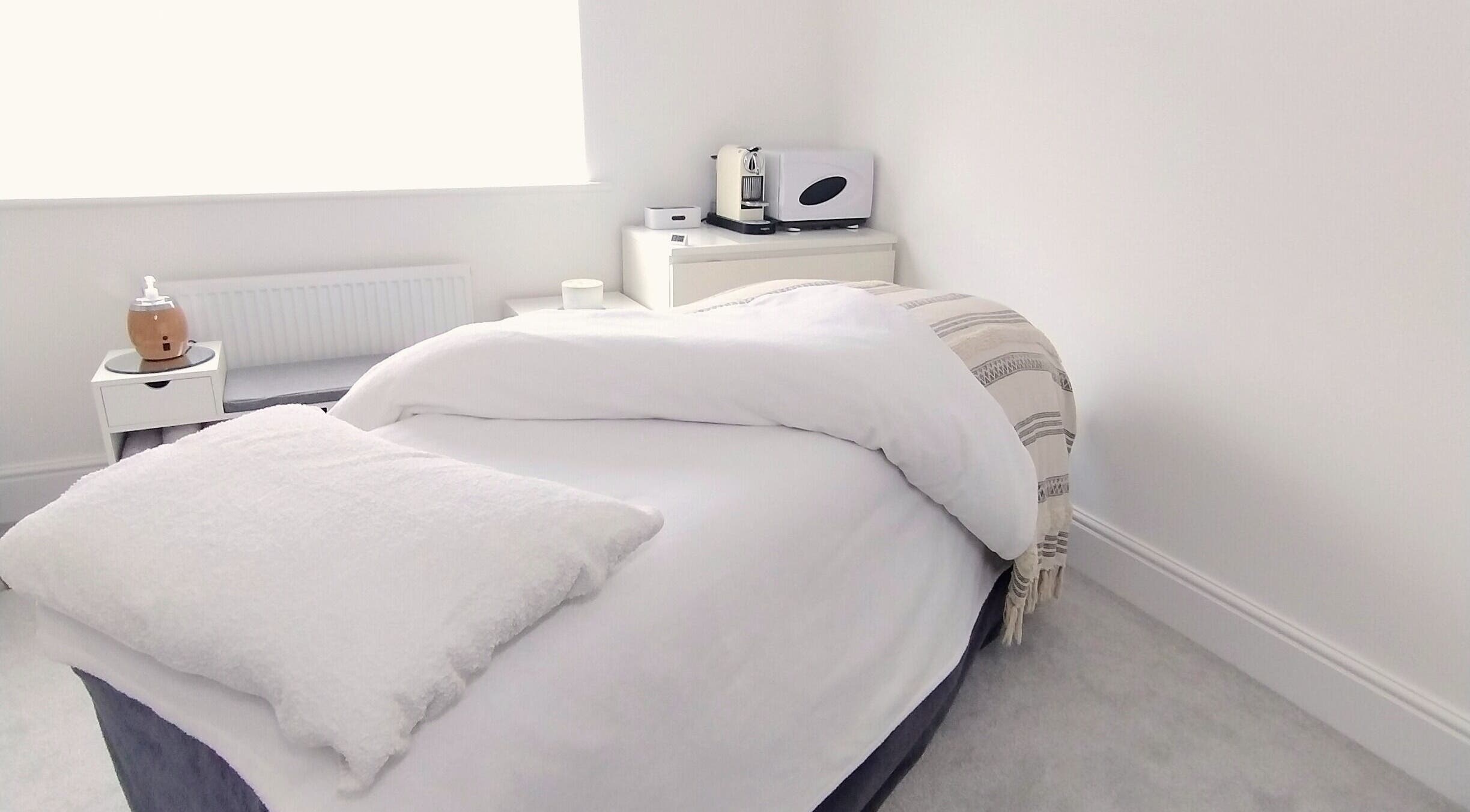 Relaxing massage room at Meadow Vale Beauty, Cottingham, England, GB with cozy bed and ambient decor.
