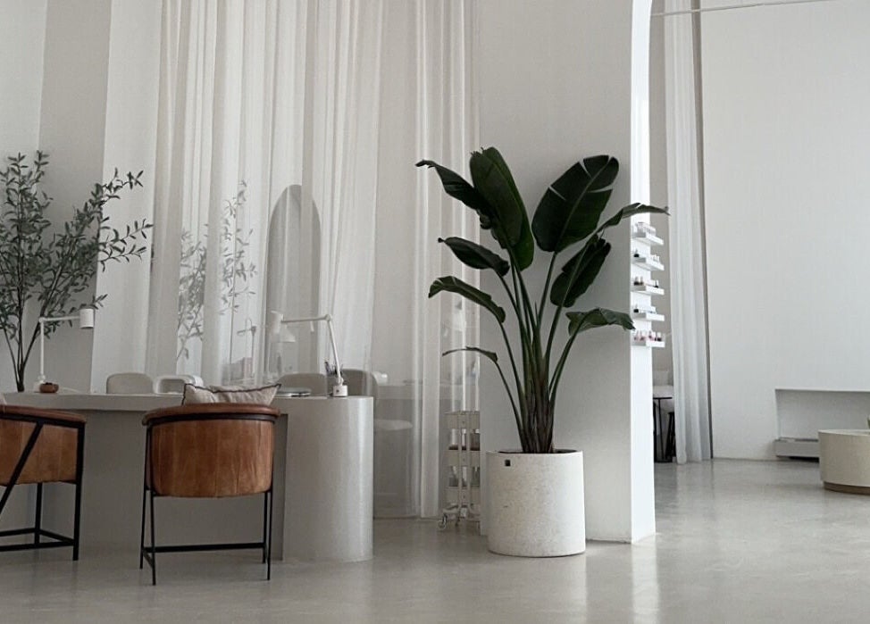 Elegant interior of De Oliva Spa in Riyadh, SA, featuring sleek furniture and lush plants.