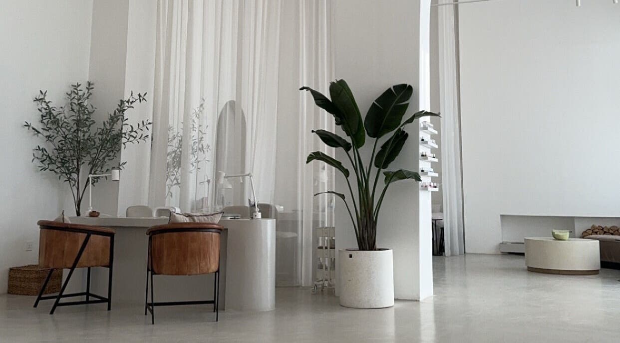 Elegant interior of De Oliva Spa in Riyadh, SA, featuring sleek furniture and lush plants.