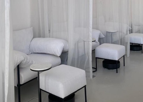 Cozy relaxation area at De Oliva Spa, Riyadh, SA, with plush seating and soft curtains.