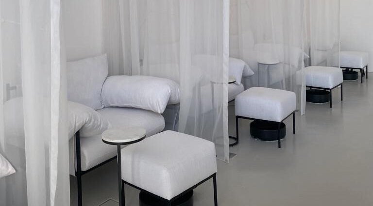Cozy relaxation area at De Oliva Spa, Riyadh, SA, with plush seating and soft curtains.