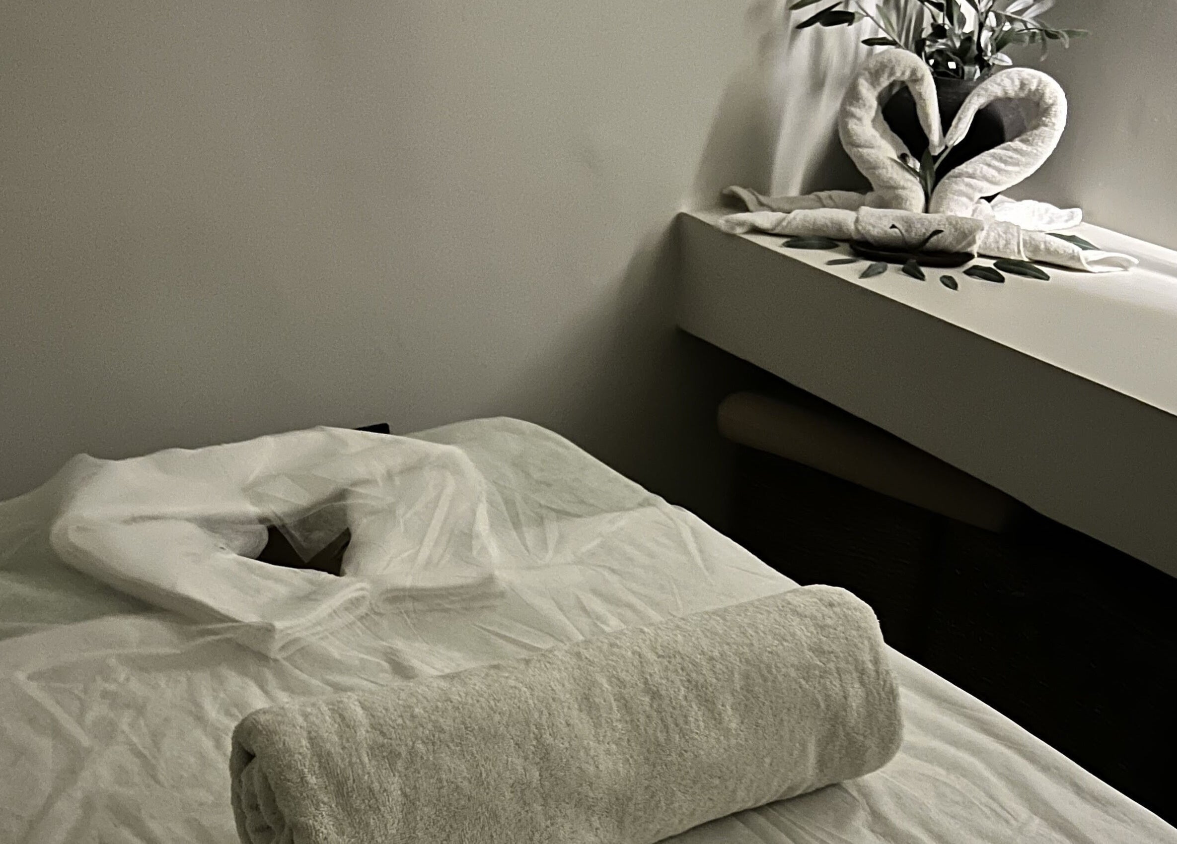 Serene massage room at De Oliva Spa in Riyadh, SA with calming decor and a fresh towel.