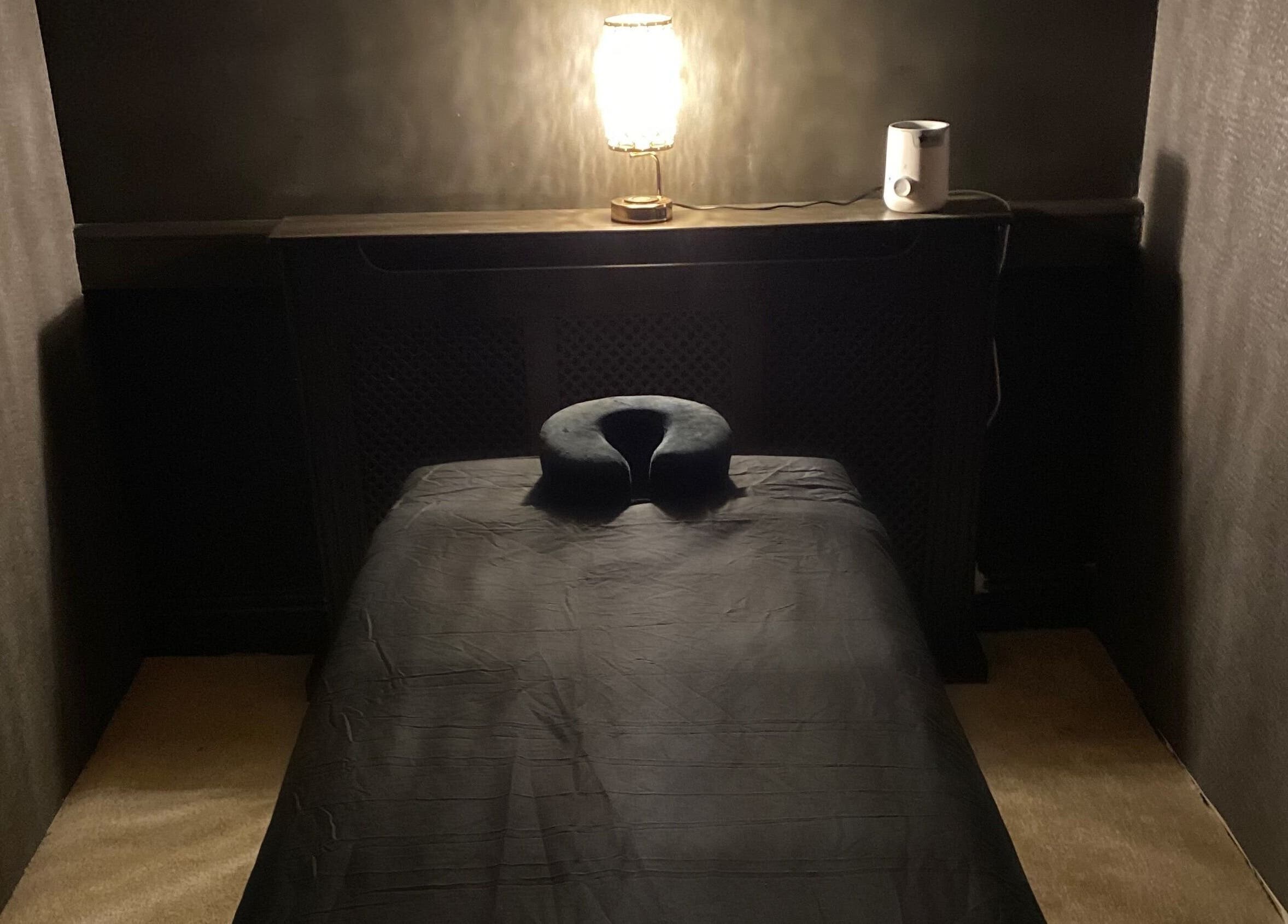 Massage table in dimly lit room at The Mansion Spa, Birmingham, England, GB offering tranquility.