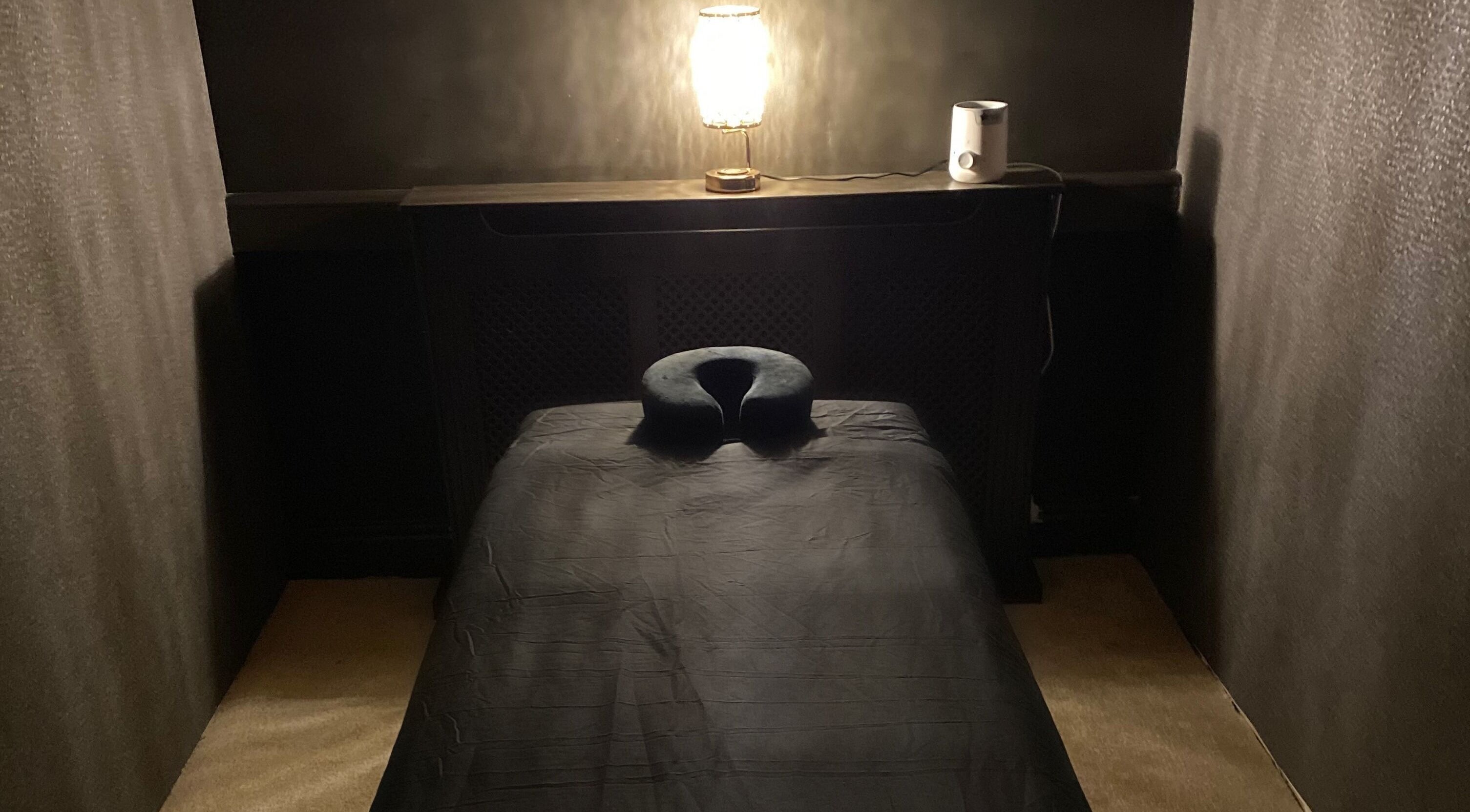Massage table in dimly lit room at The Mansion Spa, Birmingham, England, GB offering tranquility.