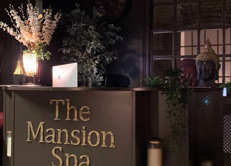 Reception area at The Mansion Spa in Birmingham, England, GB, featuring elegant decor and warm lighting.
