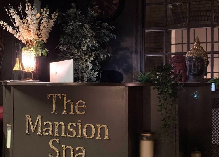Reception area at The Mansion Spa in Birmingham, England, GB, featuring elegant decor and warm lighting.